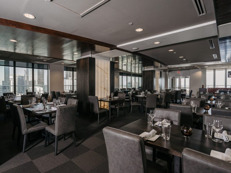 The East Dining Room features floor to ceiling windows with views of Uptown Charlotte